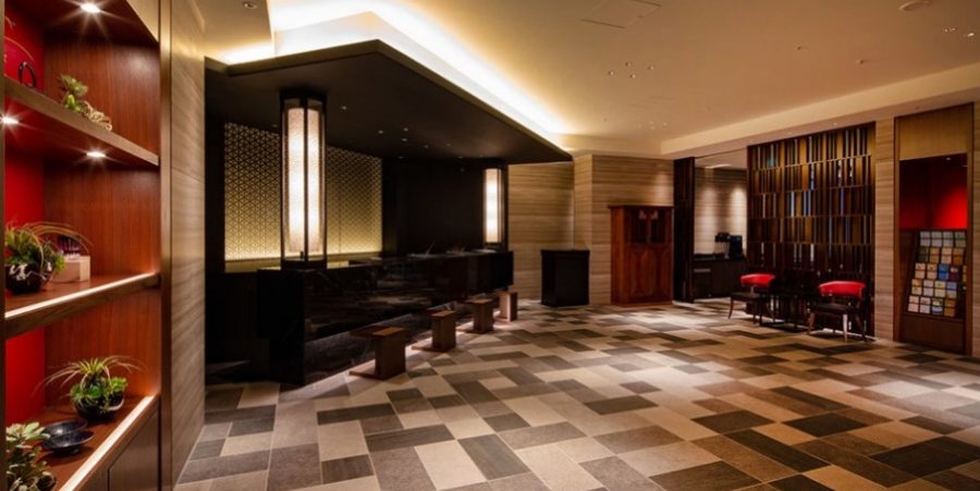 Hotel lobby featuring a tiled floor with red and black walls, creating a modern and stylish atmosphere.